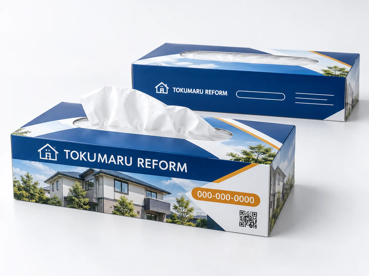 全面オリジナルデザインのボックスティッシュの作例。架空のリフォーム会社『TOKUMARU REFORM』を想定し、正面に施工イメージ写真とキャッチ、側面に社名と住所欄、天面に取り出し口を配置。社名・電話番号（000-000-0000）・QRコードはすべて架空。これはAI生成画像です。実在の人物ではありません。実在の会社・制作事例でもありません。