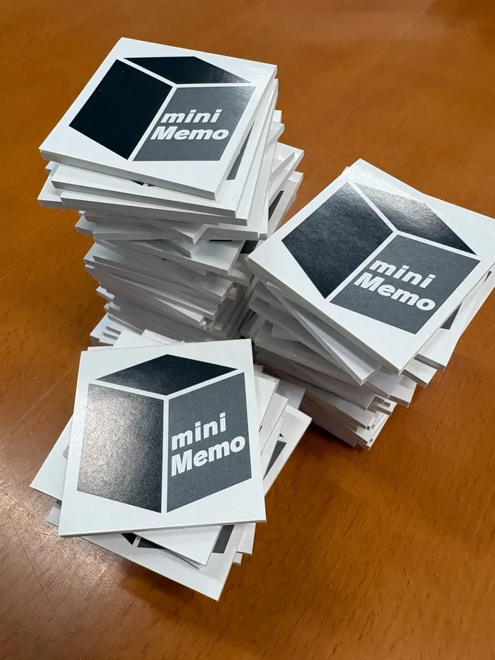 「mini Memo」デザインのミニメモ帳が大量に積み重なっている様子
